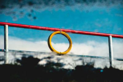 Close-up of metal railing by swimming pool against sky