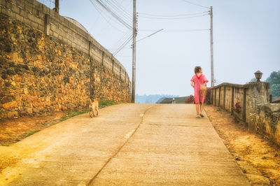 Young women walking beside the dog in the small village , calm and recreation concept