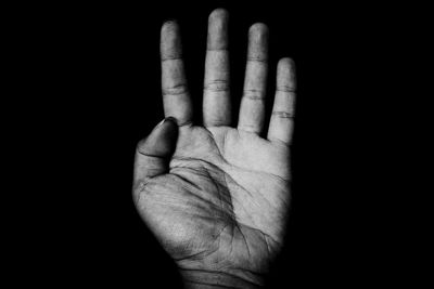 Close-up of human hand against black background