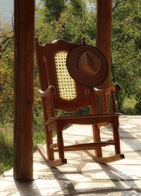 Empty chairs and table against trees on sunny day