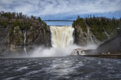 Scenic view of waterfall against sky