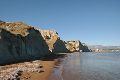 Scenic view of sea and mountains against clear sky