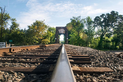 Railroad tracks by trees against sky