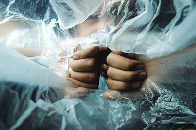 Close-up of woman hand on bed