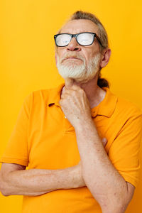 Senior man against yellow background