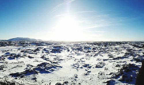 Snow covered landscape against sky