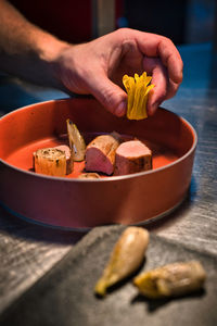 Cropped hands of person preparing food on table