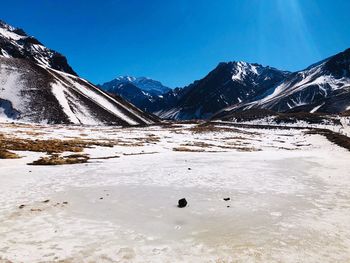 Scenic view of snowcapped mountains against clear blue sky