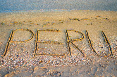 High angle view of text drawn on shore at beach