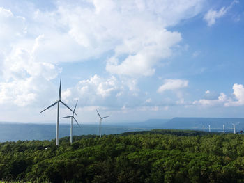 Wind turbines on land against sky