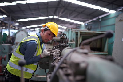 Rear view of man working in factory