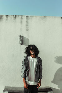 Portrait of man standing against wall