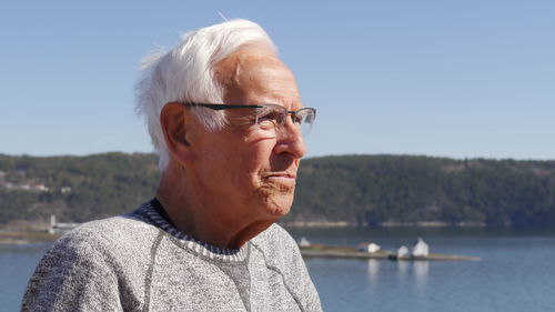 Man looking away against lake and sky