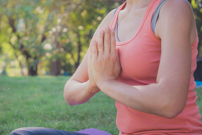 Midsection of woman sitting at park