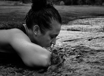 Side view of woman lying at shore