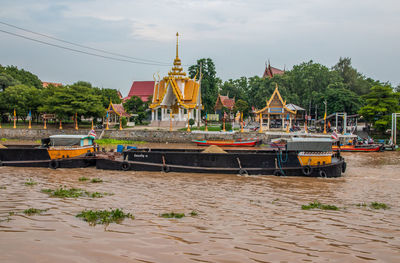 Boats moored in river against sky