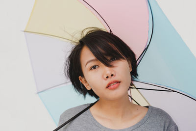 Portrait of beautiful young woman with multi colored umbrella