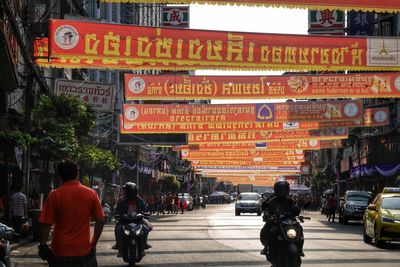 People riding motorcycle on street in city