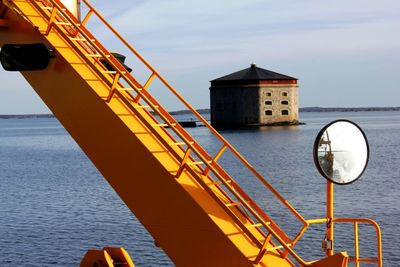 Built structure by sea against sky