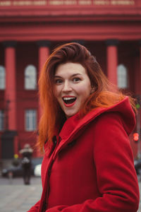 Close up excited woman wearing red coat on street portrait picture