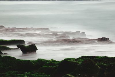 Idyllic shot of rock formation by sea