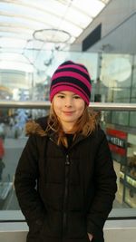 Portrait of cute girl standing against railing