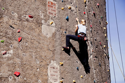 Low angle view of woman rock climbing