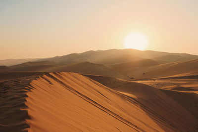 Scenic view of desert against sky during sunset