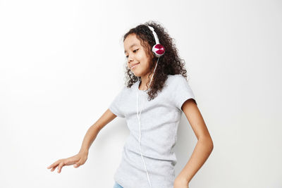 Portrait of young woman standing against white background