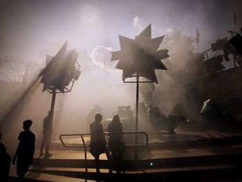 People at music concert against sky at night