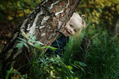 Portrait of girl on tree trunk in forest