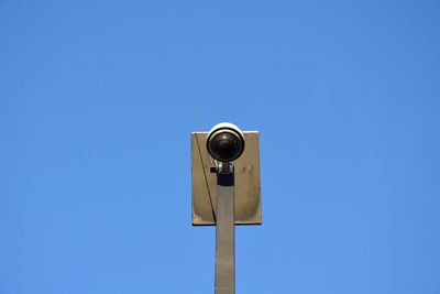 Low angle view of telephone pole against clear blue sky