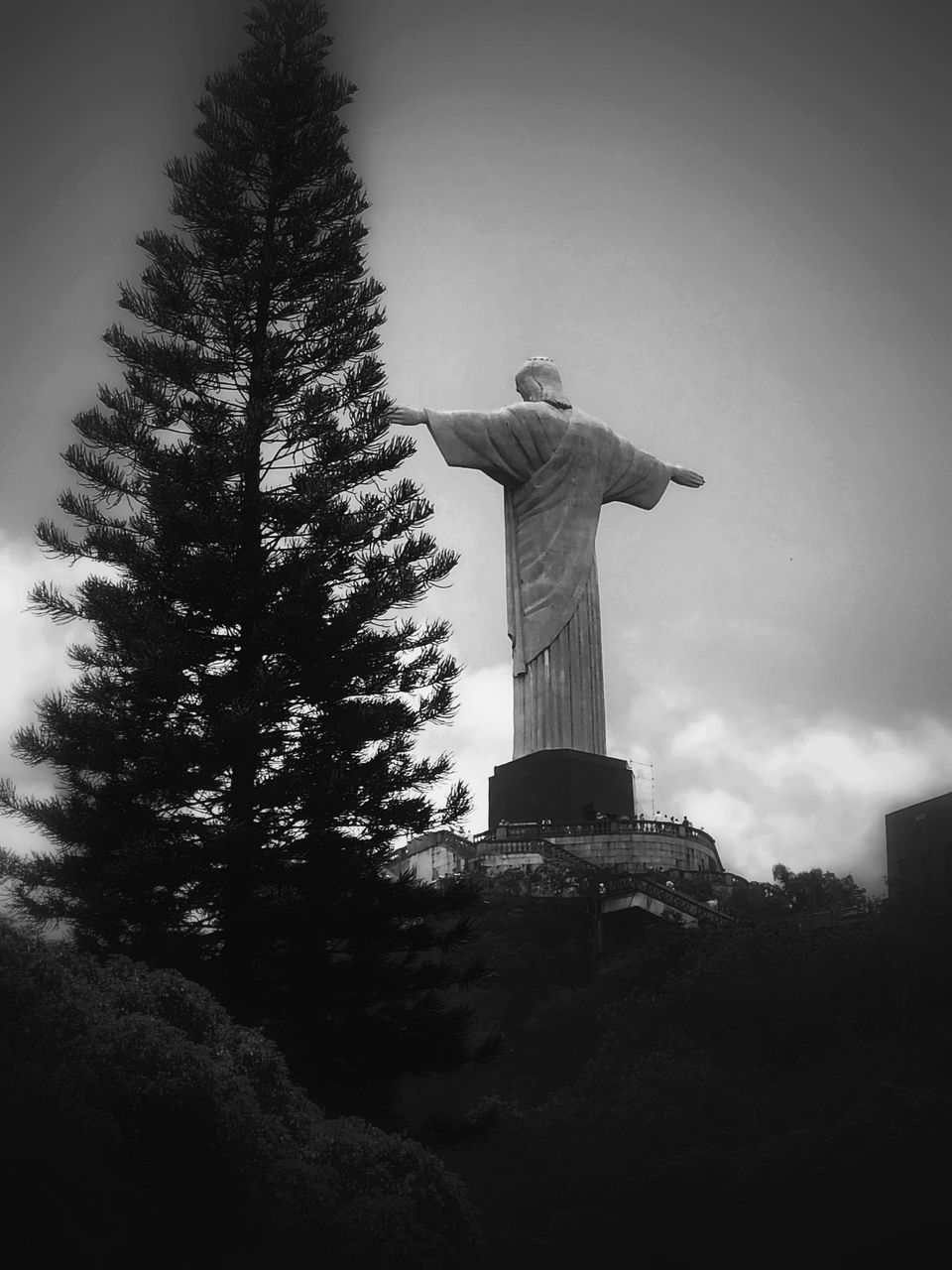 black and white, darkness, tree, sculpture, statue, monochrome, monochrome photography, plant, black, sky, white, human representation, christmas tree, nature, architecture, representation, low angle view, no people, religion, travel destinations, light, male likeness, spirituality, history, creativity, the past, belief, travel, cloud, outdoors, built structure, memorial, day, craft