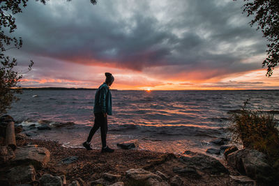  man in a blue shirt and cap watching this gem on the beach at kajaani, kainuu region, finland.