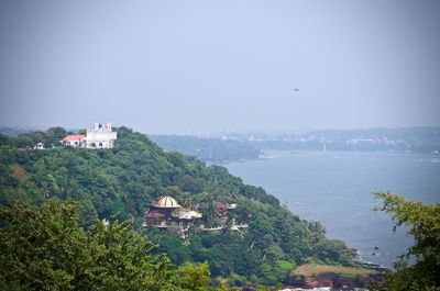 High angle view of townscape by sea against sky