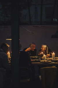 Man and woman talking to each other during dinner party at night