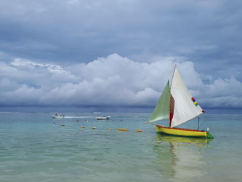 Sailboat in sea against sky