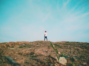 Rear view of man standing on landscape against sky