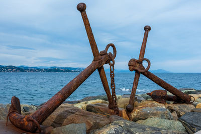 Rusty metal on beach against sky