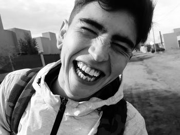 Close-up portrait of cheerful young man standing outdoors