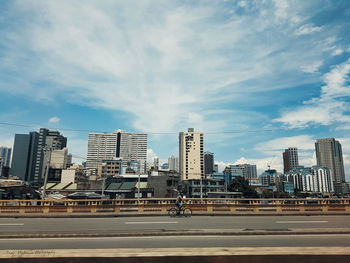 View of cityscape against cloudy sky