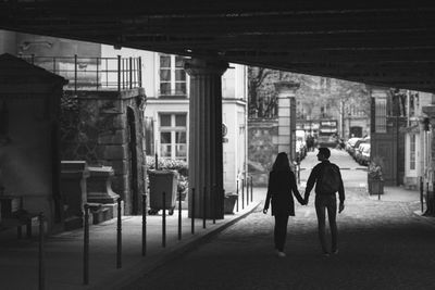 Rear view of people walking on street in city