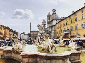 Statue of fountain in city against sky