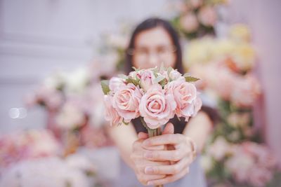 Portrait of woman holding pink rose