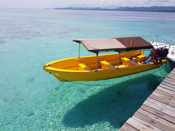 Boat moored on beach against sky