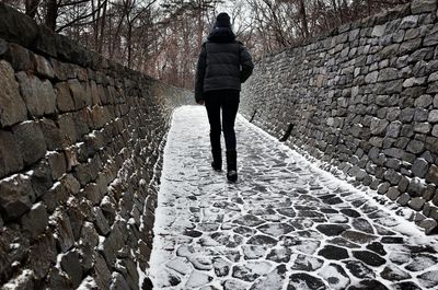 Rear view of woman walking on snow