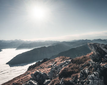 Aerial view of snowcapped mountains against sky on sunny day