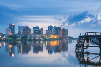 Reflection of illuminated cityscape against sky at night