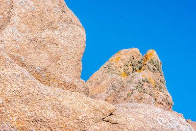 Low angle view of rock formation against clear blue sky