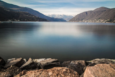 Scenic view of lake by mountains against sky